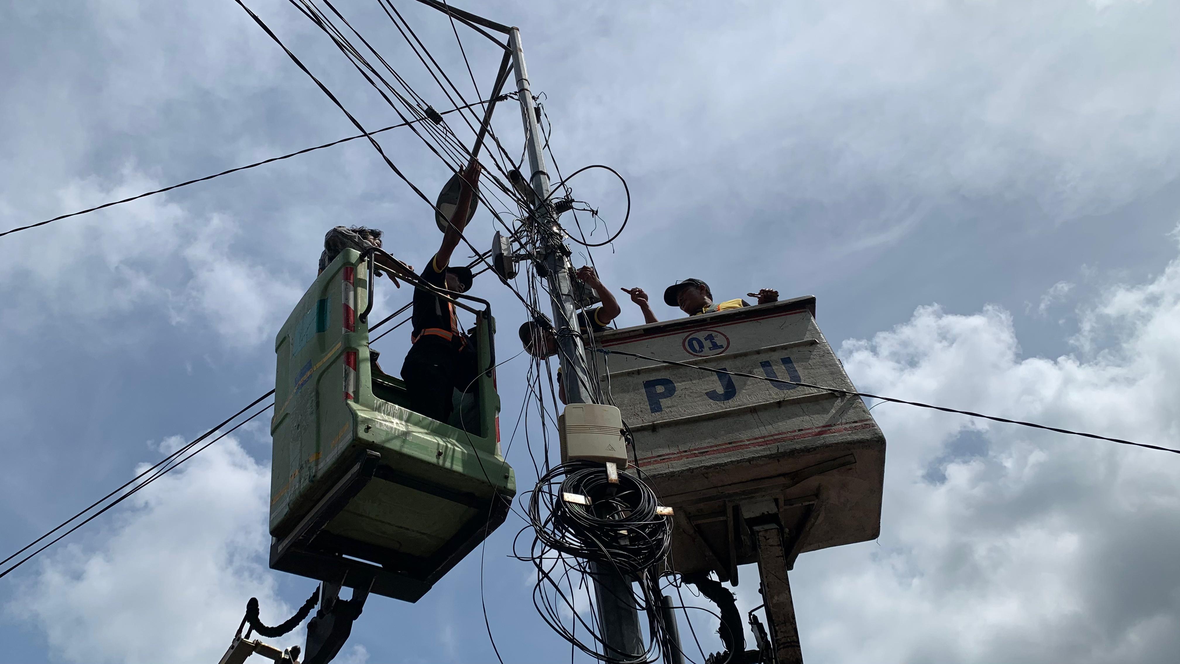 semrawut-dan-ilegal-kabel-fiber-optik-di-tiang-pju-jember-dipotong